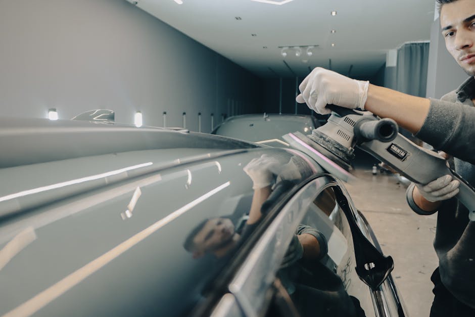 Professional auto detailer meticulously working on a vehicle's exterior